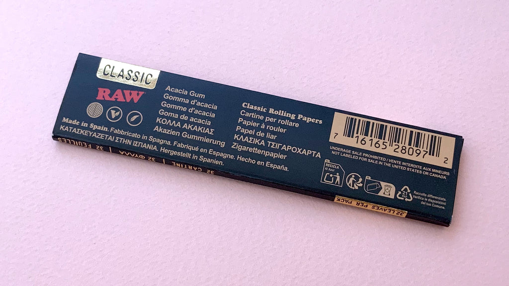 RAW Black - Classic King Size Slim, featuring ultra-thin, unbleached, and double-pressed artisan paper with a tan black and gold red themed packaging. RAW King Size Slim natural unrefined, 110x44mm, 32 leaves per booklet.